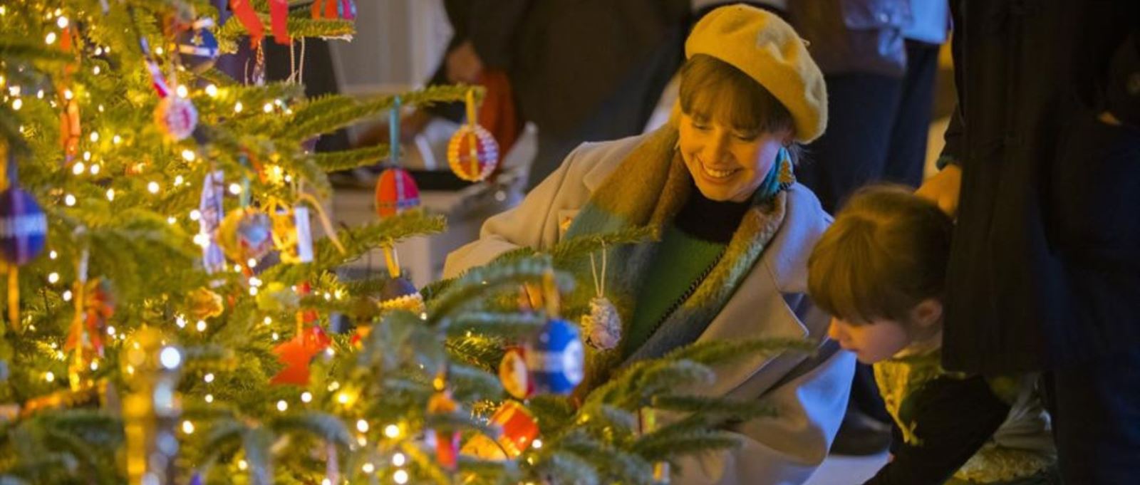 A woman and child look at a Christmas tree at Hinton Ampner